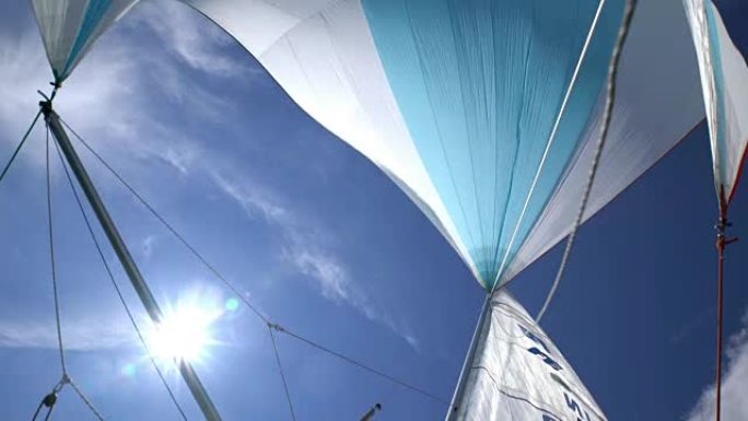 蓝天和阳光的游艇船头的大三角帆。
