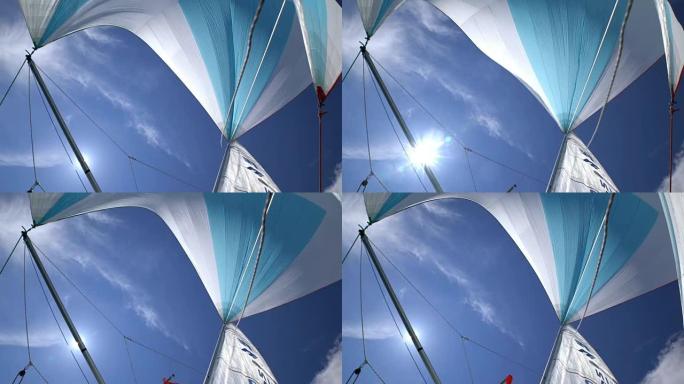 蓝天和阳光的游艇船头的大三角帆。