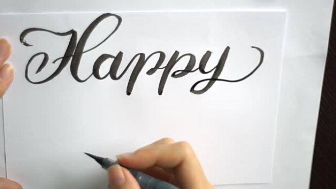 新年快乐的文字画笔在纸上