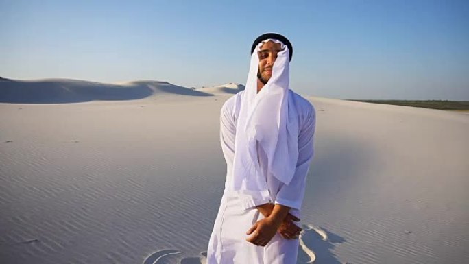 在晴朗的一天，在白色的沙漠中，慢动作自信的阿拉伯阿拉伯酋长酋长在坎杜拉