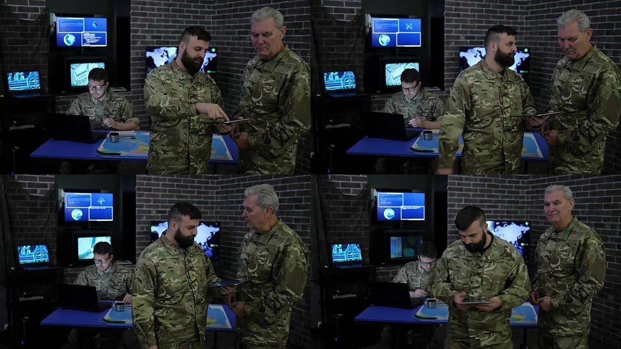 军事人员、指挥官和士兵，在军事总部，查看数字平板电脑