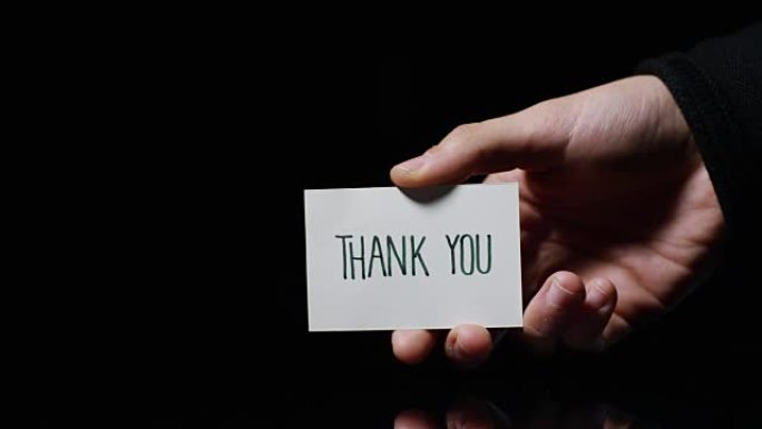 一只手展示一张卡片，上面写着: “谢谢”。商业概念，谢谢，记录网站。