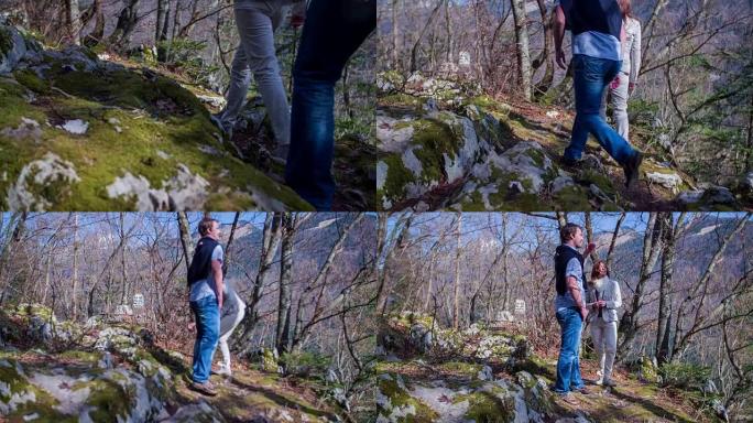 夫妇在美丽的一天走在岩石森林小径上，走到一个可以看到的地方，镜头是慢动作拍摄的。