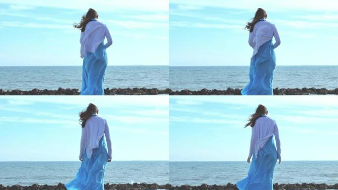 看着大海的年轻女子: 衣服在风中飘扬的美女