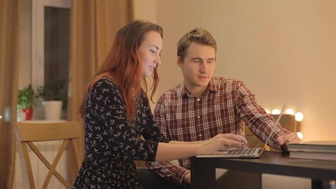 年轻夫妇在网上讨论购买笔记本电脑