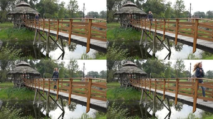 快乐的女人从桥上的木凉亭穿过公园的水槽河。