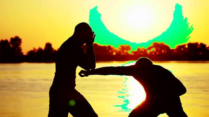 两个黑暗的男性人物，在日出时，在灯光下，拳击，在拳击中战斗，在一对打击技术中训练。在沙滩上，在货港，