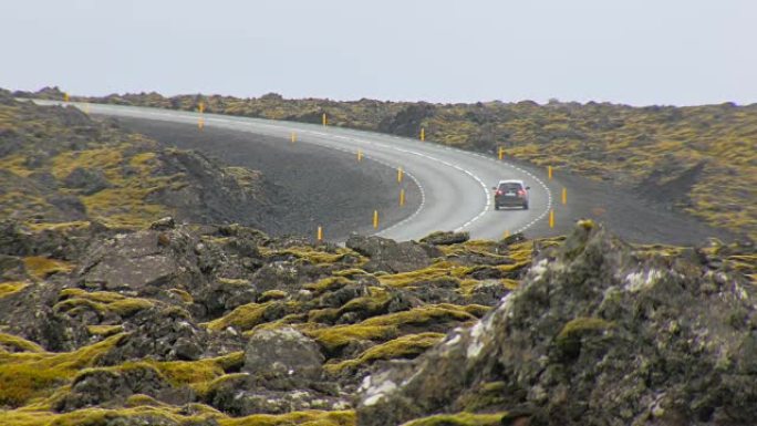 横跨旧熔岩场的现代柏油路，汽车在行驶，冰岛景观