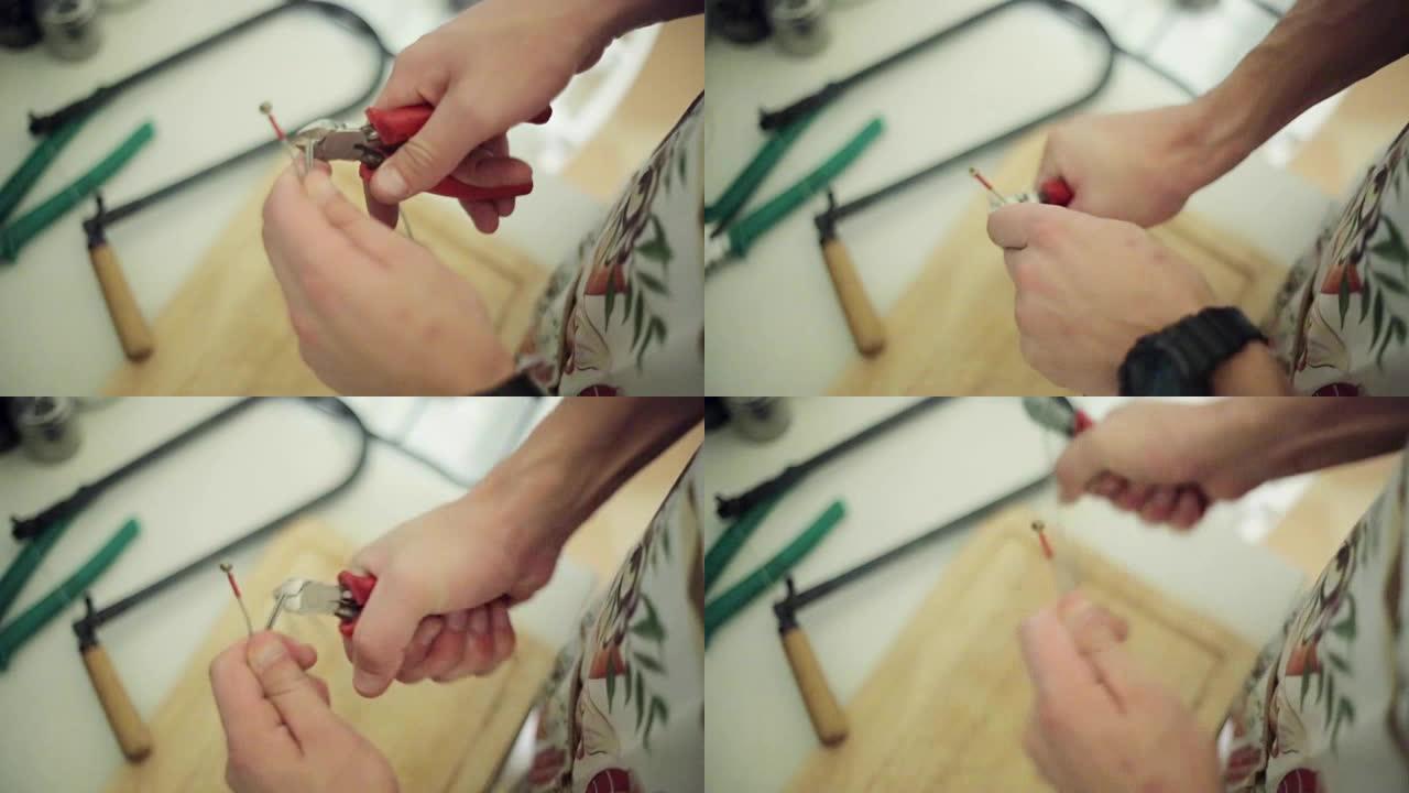 男人用手剪断，用红色钳子剪断长电线。特写