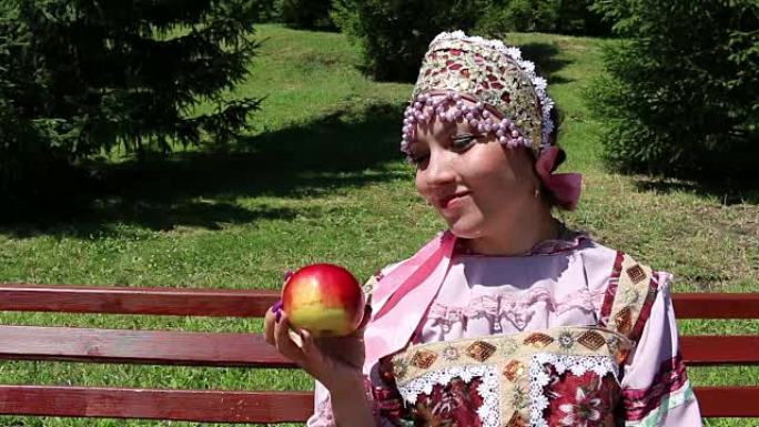 穿着俄罗斯民间服装和红苹果的女孩