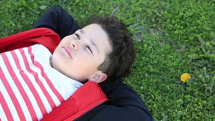 孩子躺在绿草地上放松