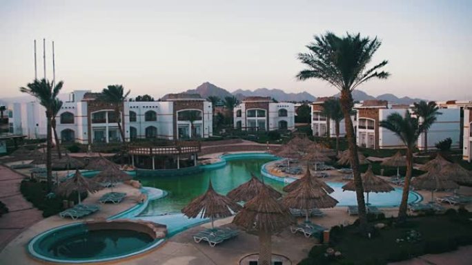 埃及有蓝色游泳池、棕榈树和日光浴床的酒店度假村