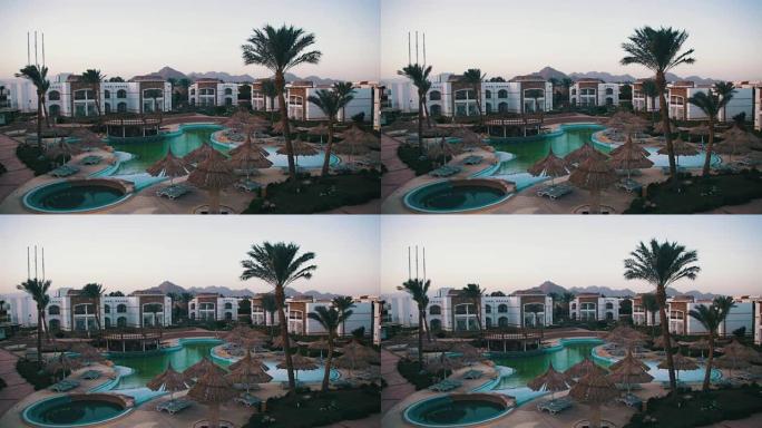 埃及有蓝色游泳池、棕榈树和日光浴床的酒店度假村
