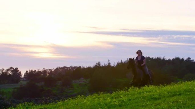 成年女子骑着一匹英国式纯种骏马，从右至左，背景是夕阳和太平洋的金色光芒，长镜头慢动作Slog3 20