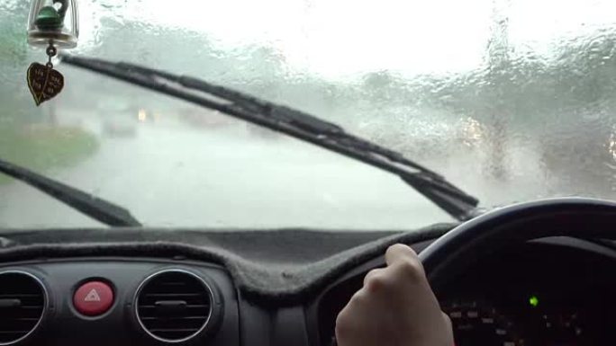 年轻女子在雨天开车。实时拍摄慢动作