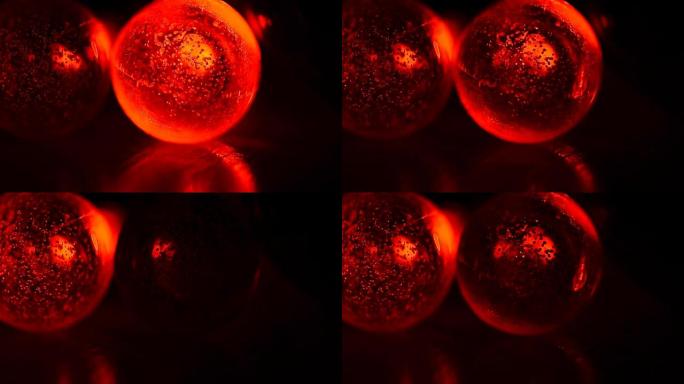 红色花环在黑暗的背景上，灯亮了，熄灭了。亲密关系，节日气氛