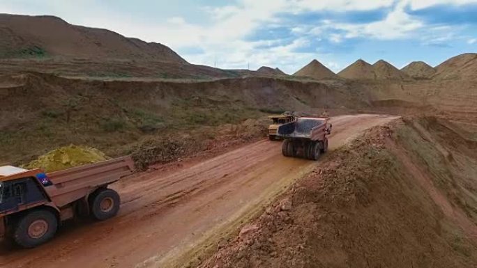 两辆自卸车从采石场运送矿石。矿山全景。巴尔汗·桑兹。矿产开发。