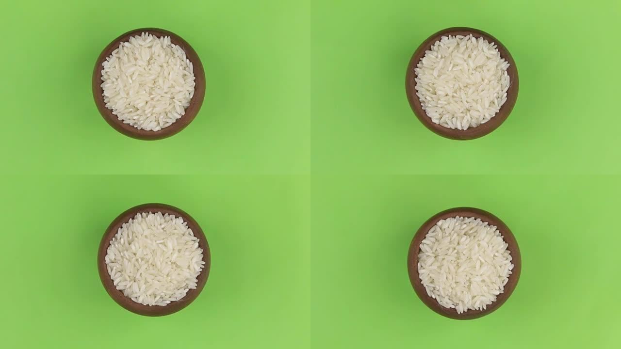 在绿色屏幕上隔离的锅中旋转米粒。