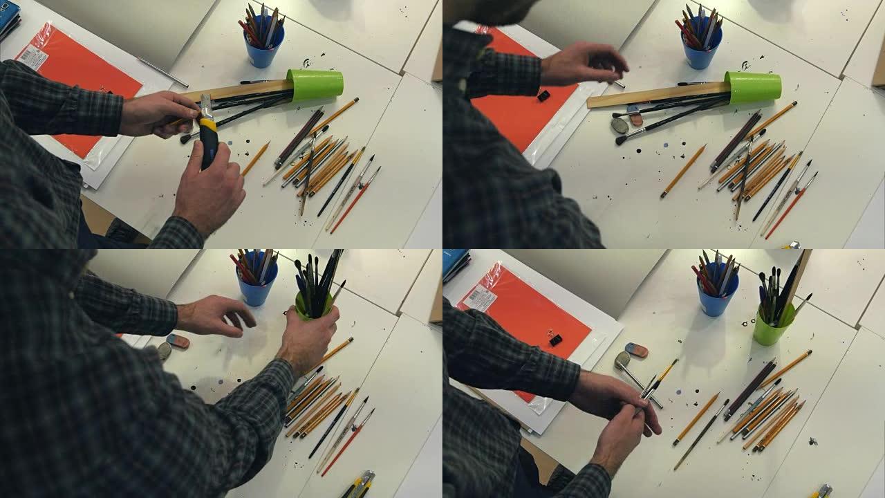 画家在不同的罐子里排列画笔和削尖的铅笔