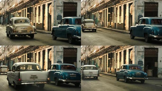 经典汽车在哈瓦那老街相互经过