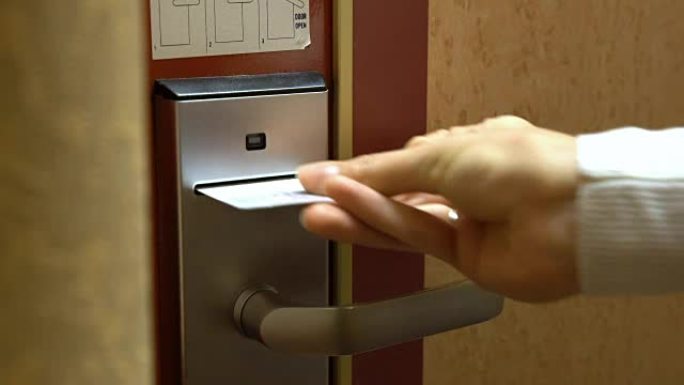 一名年轻女子用电子钥匙卡打开了他酒店房间的门。