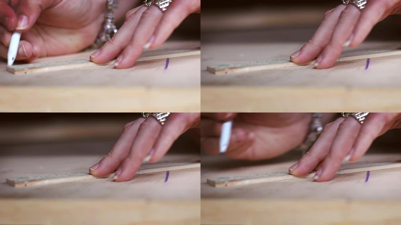 女人用钢笔沿着木板追踪木工车间项目-V2