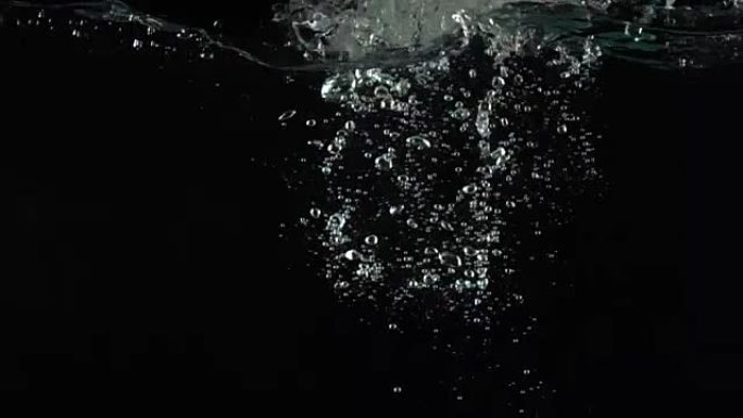 男子手伸手抓住漂浮在水中的青苹果超级慢动作镜头