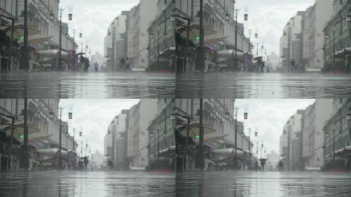 城市街道大雨日的背景。实时。雨中带伞的人上下班。模糊的波克。自然背景