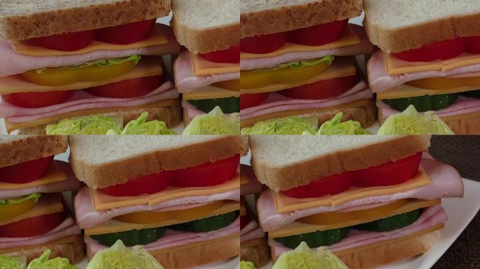 两个三明治的特写镜头，包括培根，萨拉米香肠，意大利熏火腿和新鲜蔬菜