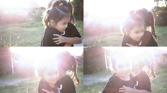 两个亚洲小女孩朋友的慢动作拥抱和日落微笑