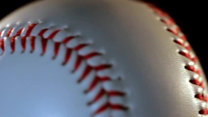 黑色背景上孤立的棒球球/白色球上的红色接缝