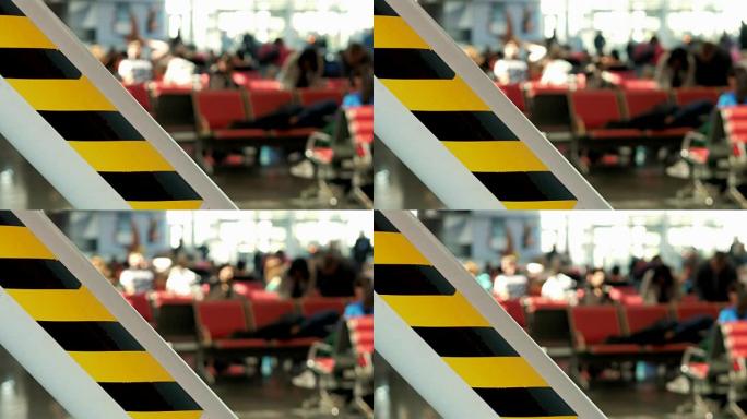 背景: 模糊的人走在机场。航班后方黄黑色带和等候区