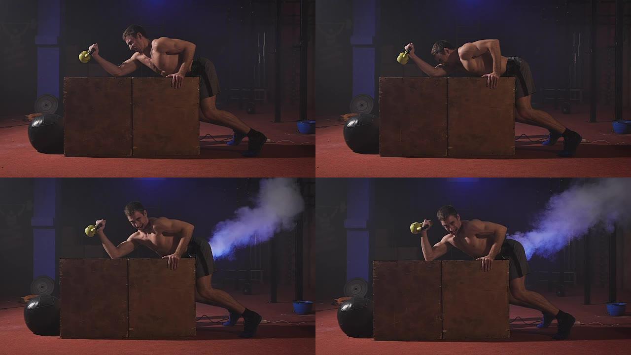 性感的赤裸上身的男人在箱子上做二头肌运动，获得很大的力量，像机车一样喘着气