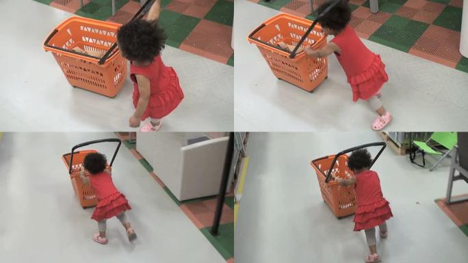 小女孩推着塑料购物车