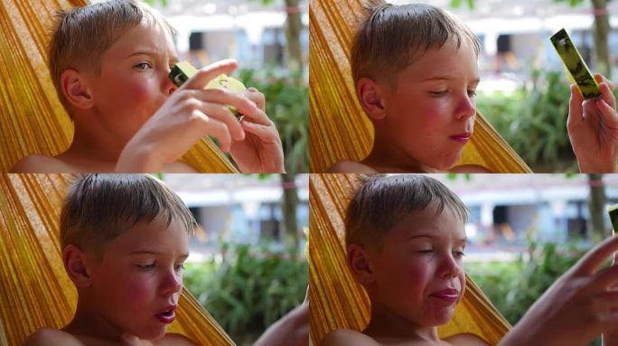 孩子在炎热的夏日躺在吊床上吃甜美多汁的西瓜
