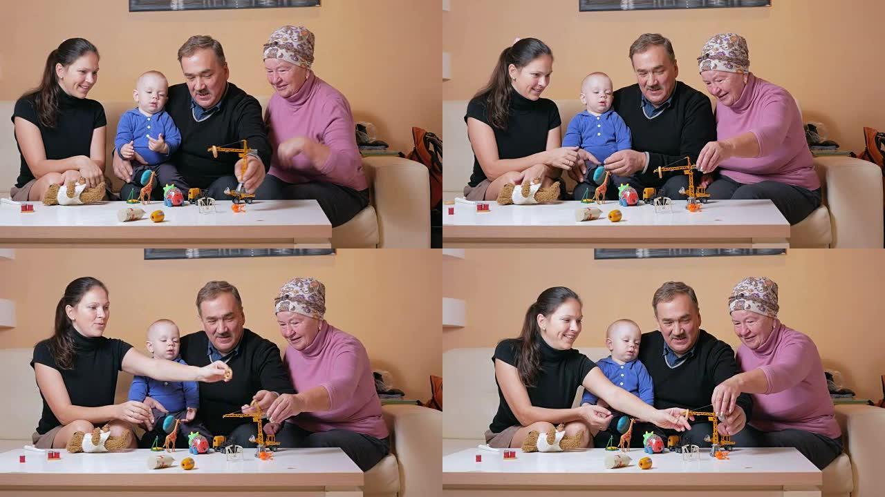 有一个婴儿的幸福大家庭她的母亲和祖父母在沙发上玩得开心。他们彼此欢笑和交谈。家庭幸福的概念