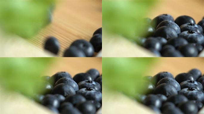 许多蓝莓在木质表面滚动。慢动作。