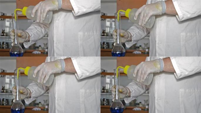 手握实验室技术稀释蓝色液体的手套