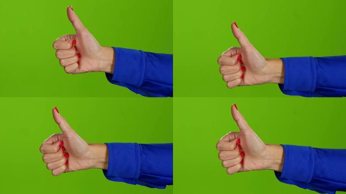 在绿色屏幕背景上竖起大拇指的手。手语