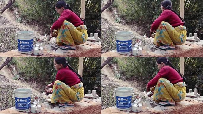 印度uttrakhand丘陵地区的一名妇女在户外清洁用具。