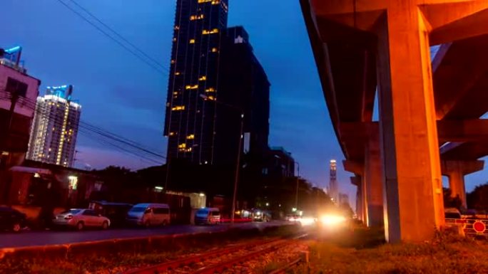 夜间交通和火车在高速公路地下室旁边的铁路上。