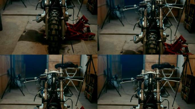 年轻的高加索男性机械师在车库里组装一辆定制的咖啡馆赛车摩托车