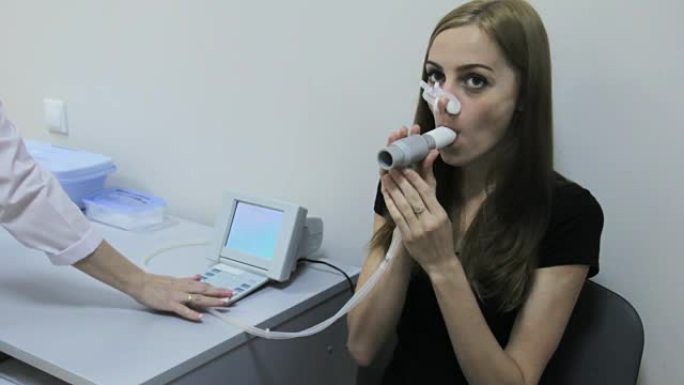 医生正在机器肺活量计上测试肺部女孩的能力