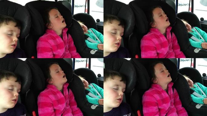 三个孩子从假期开车回来很长一段时间后在车里睡着了