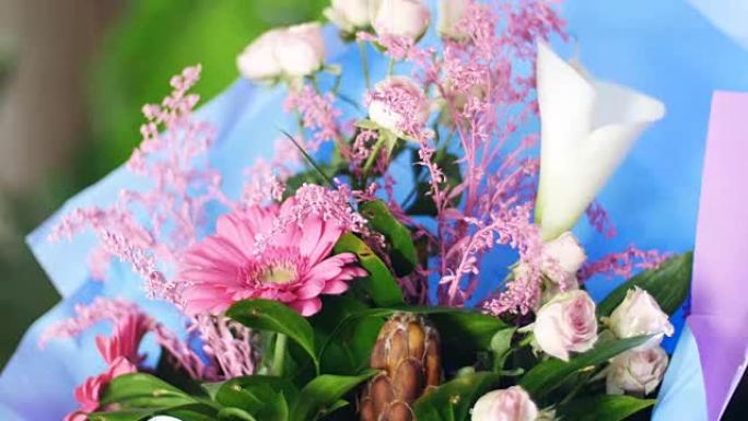 特写，花束在光线中，旋转，花卉成分由粉红色非洲菊，Protea，马蹄莲，玫瑰亚娜奶油，一枝黄花组成