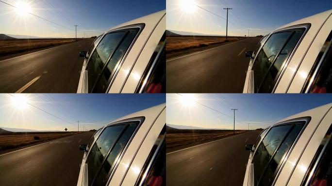 摄像机附在汽车在荒芜的高速公路上行驶的侧面。沙漠公路上汽车行驶的视点