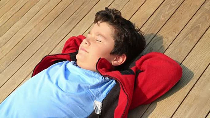 一个快乐英俊的小男孩在户外阳光下放松的肖像