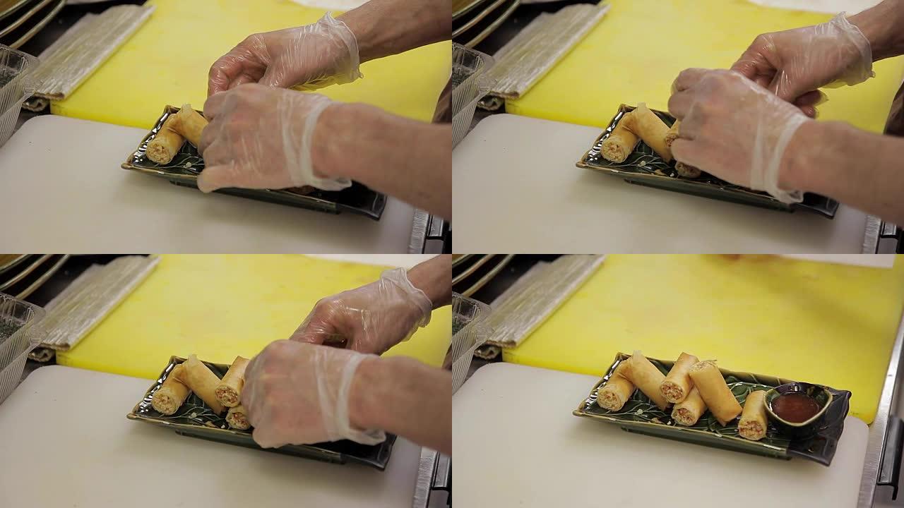 在厨房里，戴着手套的厨师放了很长的盘子卷