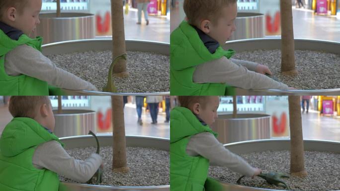 在购物中心玩玩具恐龙的孩子