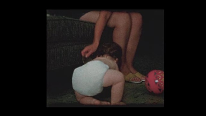 母亲给尿布中的男婴玩杯垫